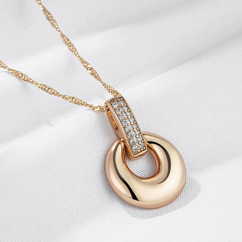 Rose gold pendant necklace with crystal-embellished bail, displayed on a light beige background