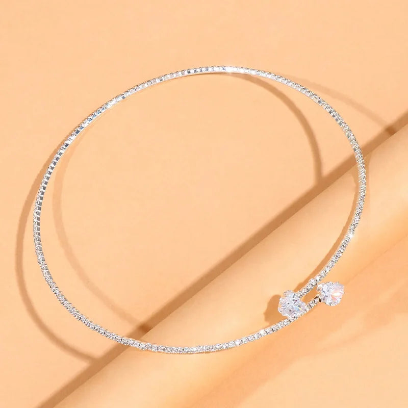 Sparkling solitaire choker necklace with cubic zirconia stones displayed on a soft beige surface.