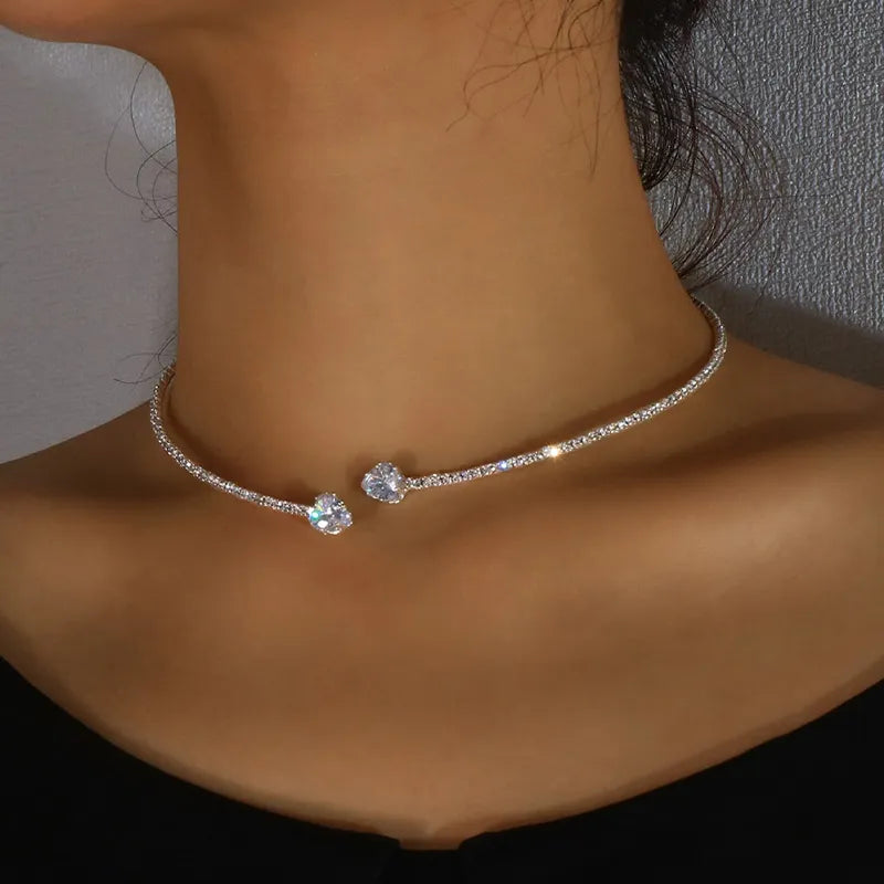 Close-up of a woman wearing a silver sparkling solitaire choker necklace with cubic zirconia stones, highlighting its sleek adjustable design.